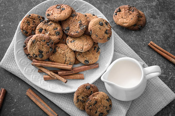 Chocolate chip oatmeal cookies and jug of milk on table