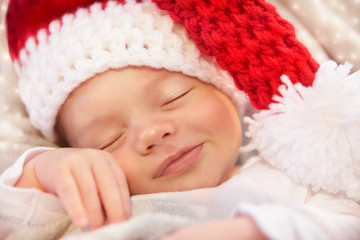 Cute baby Santa smiling in the sleep