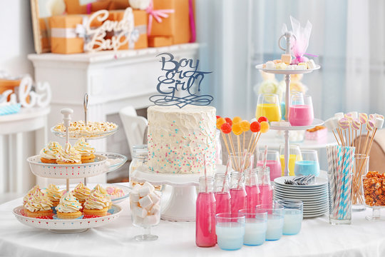 "Boy or girl" cake and different treats for baby shower party on table indoors