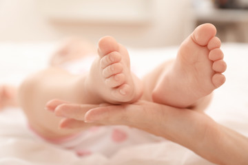 Mother holding her baby's feet, closeup