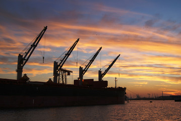 Fototapeta na wymiar Ship loading cargo in the Port of Rotterdam at Sunset