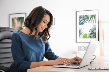 Young woman using laptop in office