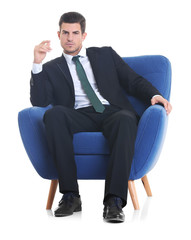 Handsome young man sitting in armchair on white background