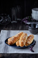 On a wooden table on a plate a bunch of sausages in a dough