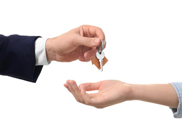 Real estate agent giving key of new house to woman on white background