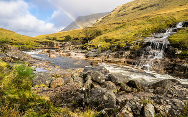 Landscape with waterfall and rainbow in Glen Coe, Scotland
