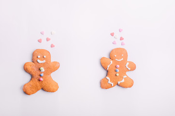 Gingerbread cookies couple for Valentines Day. Man and woman with emotions in the shape of hearts on the white background. Love and happy family concept. Selective focus. Space for text