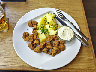 Tasty fried mushrooms with mashed potatoes on plate.