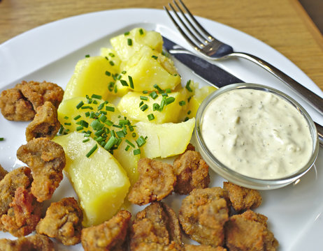 Tasty fried mushrooms with mashed potatoes on plate.