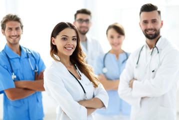 Attractive female doctor with medical stethoscope in front of medical group