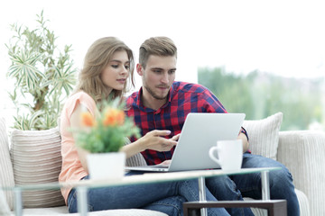 young woman showing important information to her boyfriend on the laptop screen