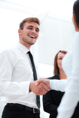 Fototapeta na wymiar funny smiling businessman shaking hands with his partner.