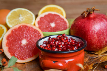 Mix of tropical fruits with lemon, orange, grapefruit, pomegranate on a vintage wooden board