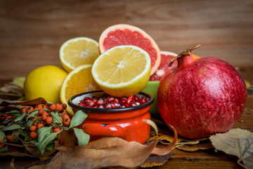 Mix of tropical fruits with lemon, orange, grapefruit, pomegranate on a vintage wooden board