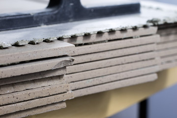 Cut tiles on the floor stacked. Tiles and masonry rugs for laying tiles.