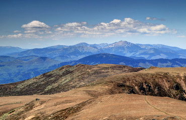View of sunlit barren main ridge of Low Tatras towards Dumbier, highest peak of range, with white cumulus clouds in a sunny spring day from Kralova Hola peak, Low Tatra National Park, Slovakia, Europe © nogreenabove2k