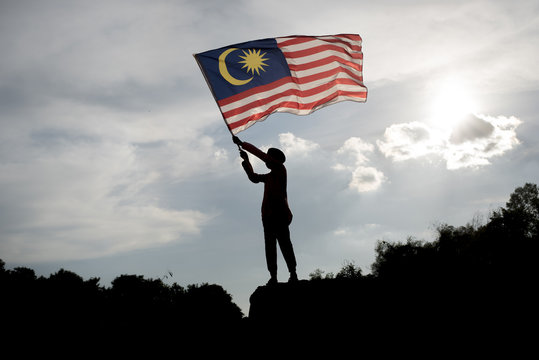 Silhouette Of A Boy Holding Malaysia Flag