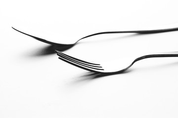 Fork and spoon in white background / A fork, in cutlery or kitchenware , Spoons are used primarily for eating liquid or semi-liquid foods