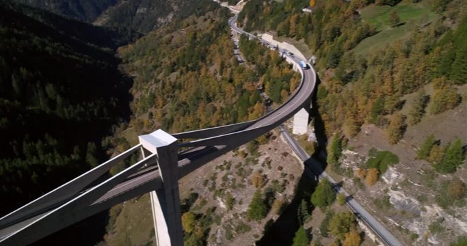 Truck on a bridge, Cinema 4k aerial view following a truck driving over a huge bridge, between mountains, on a sunny fall day, on simplon pass, in wallis, of the alps in Switzerland
