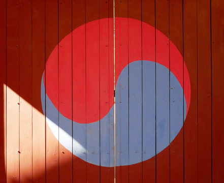 A symbol of Korea's iconic Taegeuk mark drawn on the old door.