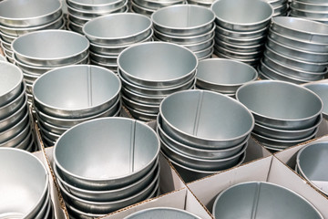 Stacks of silver tin buckets in white corrugated boxes.