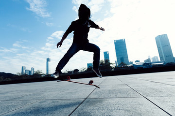 Skateboarder doing a heel flip on city with skateboard