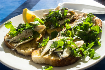 Anchovis auf Knoblauchbrot mit Salat als Vorspeise