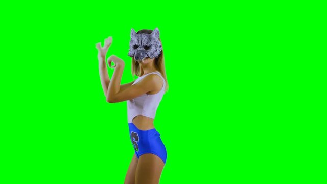 Girl in wolf mask scratches at green background