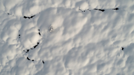 Texture of fresh snow seen from above with soft highlights and shadows