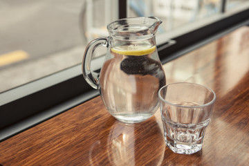 water jug with lemon on the wood table.
