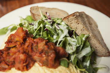 omelet with spicy chicken with bread on the white dish.