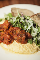 omelet with spicy chicken with bread on the white dish.