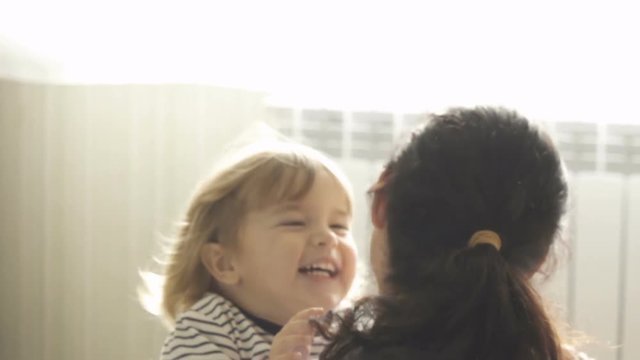 Little Son Rushes Into Mother's Arms At Home. Slow motion. Big Hug. Family values. Kiss.