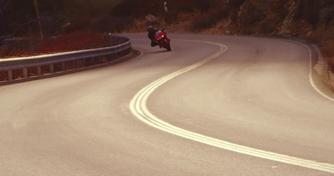 Slow Motion Extreme Motorcyclist Riding Sport Bike On Curvy Road With Lens Flare