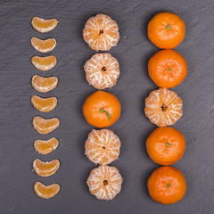 Fresh orange, tangerine fruit, mandarin pattern, top view on a black slate background, close up