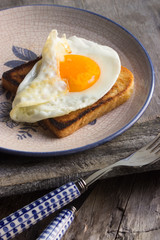 Spiegelei auf Toast auf einem Teller angerichtet  mit Messer und Gabel