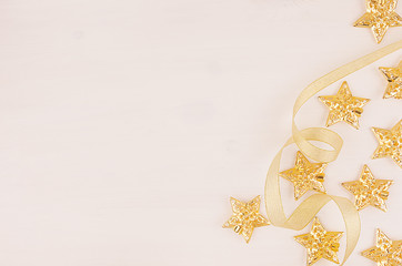 Christmas tree of gold stars, curl ribbons on soft white wood board, half.