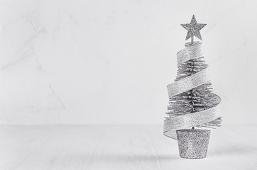 Christmas silver tree and tape on white soft wood background. Festive interior, copy space.