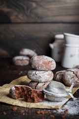 Deliciouse Homemade Chocolate crinkle cookies with powdered sugar icing on dark stone table background. Copy space