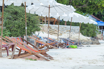 Sun loungers and beach umbrellas on the beach At Koh Samet Thailand.Happy Holidays Concept