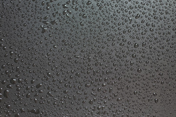 Small liquid drops on a black background.