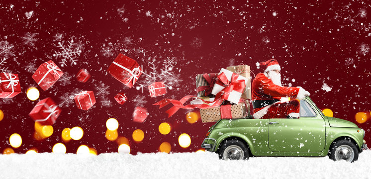 Santa Claus on car delivering Christmas or New Year gifts at snowy red background