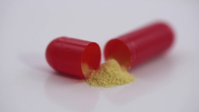 Pharmaceuticals and drugs, view of the opened capsule with medicine, isolated.
