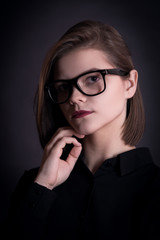 Beautiful model in glasses on a black background in studio