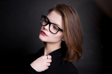 Beautiful model in glasses on a black background in studio