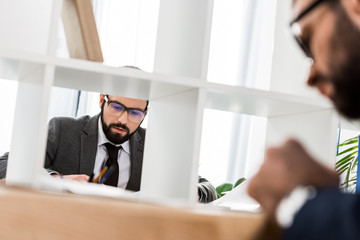view through partition on businessman working in office