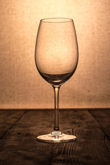 Silhouette of a vintage glass on a wooden table and cloth background