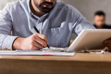 cropped image of businessman using tablet at work