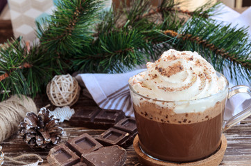 .Cup of hot chocolate cocoa with whipped cream and dark chocolate crumbs on wooden table with  Christmas  decoration. Delicious cold weather beverage concept. Christmas drink background. .