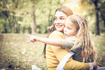 Mother and daughter sitting in park.
